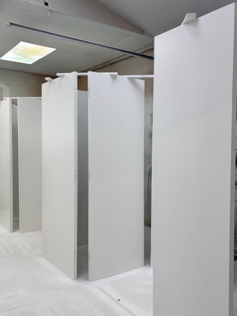 Doors being professionally spray painted in a spray booth